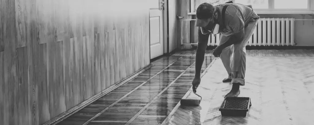 Profissional aplicando revestimento de piso, representando serviços de flooring nos EUA.